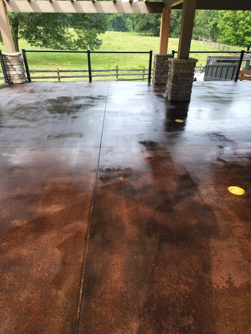 Rich brown acid-stained concrete floor under an open pavilion